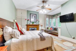 a bedroom with a bed and a flat screen tv at Historic Mobile Home Walk to Downtown Attractions in Mobile