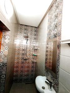 y baño con lavabo y ducha. en Chez trina house, en Bizerte