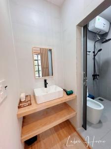 a bathroom with a white sink and a mirror at Labri Home Da Lat in Da Lat