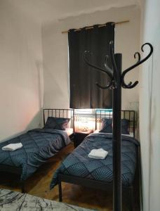 2 camas individuales en una habitación con ventana en Waterfall Hostel en Sarajevo