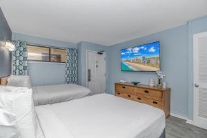 マートルビーチにある5th Floor Direct Oceanfront Double Suite Sleeps 6 Meridian Plaza 503のベッドが2つあり、壁に絵が飾られた寝室 +84枚の写真