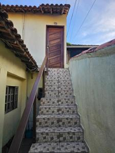 schody prowadzące do domu z drewnianymi drzwiami w obiekcie Apartamento Buziano w mieście Búzios