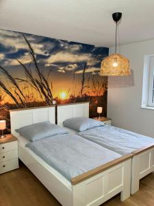 1 dormitorio con 1 cama con una pintura en la pared en Landperle 2, en Ulsnis