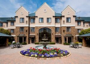 a large building with a fountain in the courtyard at Staybridge Suites - Charlotte Ballantyne, an IHG Hotel in Charlotte