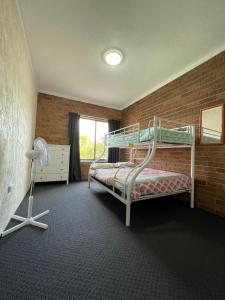 a bedroom with a bunk bed in a brick wall at Woody Wonder Unit 2 South West Rocks in South West Rocks
