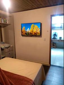 a bedroom with a flat screen tv on the wall at Pousada Sol de Primavera in Arujá