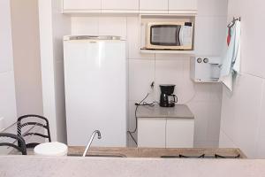 eine kleine Küche mit einem Kühlschrank und einer Mikrowelle in der Unterkunft Hosts BR - Estúdio em Boa Viagem(s/taxas) in Recife