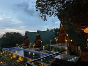a house with a swimming pool next to a building at Sundown Lake Hotel & Spa in Habarana