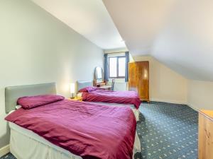 メルボルンにあるStenson Hill Farmの紫のシーツが備わるホテルルームのベッド2台