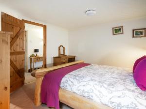 a bedroom with a bed and a wooden cabinet at The Nook in Yorkley