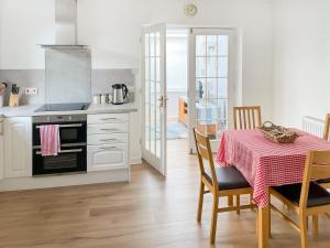 uma cozinha com uma mesa com uma toalha de mesa cor-de-rosa em Aidan - 28254 em Seahouses
