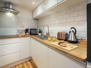 a kitchen with white cabinets and a counter top at Garden Flat in Torquay