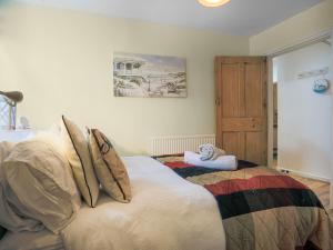 a bedroom with a bed with pillows on it at Garden Flat in Torquay