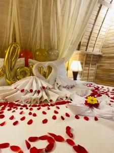 a bed with red rose petals and hearts on it at The Blooms Villas in Bedugul
