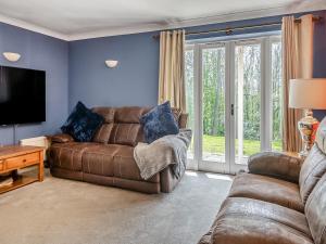 a living room with a couch and a tv at Dunburgh Wood in Beccles
