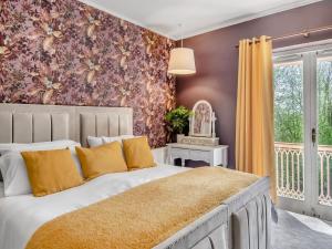 a bedroom with a large bed with yellow pillows at Dunburgh Wood in Beccles