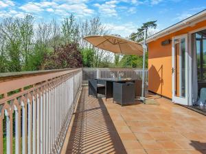a patio with a table and an umbrella at Dunburgh Wood in Beccles