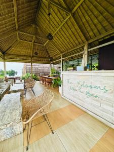 a patio with chairs and a wall with writing on it at The Blooms Villas in Bedugul