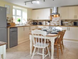 a kitchen with a white table and chairs at Frondeg in Blaenporth