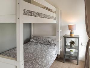 a white bunk bed in a bedroom with a night stand at Frondeg in Blaenporth