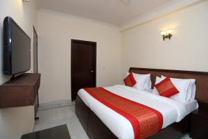 een slaapkamer met een groot bed met rode kussens bij OYO Krishna residency in Gurgaon