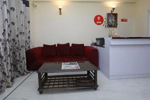 een woonkamer met een rode bank en een salontafel bij OYO Krishna residency in Gurgaon