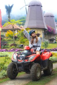 a woman is riding on a four wheeler at The Blooms Villas in Bedugul