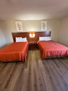 ein Hotelzimmer mit 2 Betten mit roter Bettwäsche in der Unterkunft Rosewood Inn in Union City