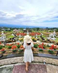 a little girl in a hat looking at a garden at The Blooms Villas in Bedugul
