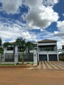 a house with a palm tree in front of it at holiday villa in Harare