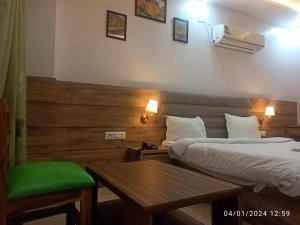 Habitación de hotel con 2 camas y mesa en Icyhotels sunrise 92, en Noida