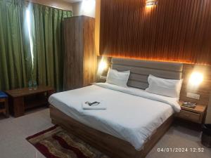 1 dormitorio con 1 cama grande con sábanas blancas en Icyhotels sunrise 92, en Noida
