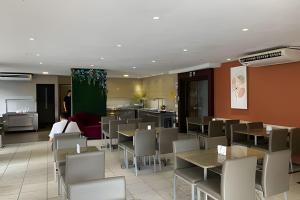 Hosts BR - Flat Vista Mar no Meireles في فورتاليزا: غرفة طعام مع طاولات وكراسي في مطعم