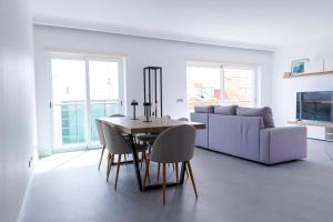 a dining room with a table and a couch at Casa do Sal in Sesimbra