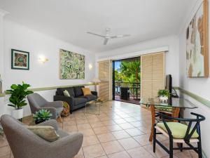 - un salon avec un canapé et une table dans l'établissement Waterfront Terraces, à Cairns