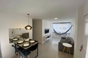 a kitchen and living room with a table and chairs at Hosts BR - Apartamentos funcionais in Fortaleza