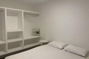 a white bedroom with a bed and shelves at Hosts BR - Apartamentos funcionais in Fortaleza +58 photos