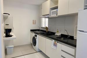 Hosts BR - Apartamentos funcionais في فورتاليزا: مطبخ أبيض مع حوض وموقد