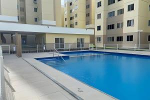 une image d'une piscine en face d'un bâtiment dans l'établissement Hosts BR - Apartamentos funcionais, à Fortaleza