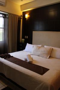 um quarto com uma cama grande e uma cabeceira preta em Posada Vista Tepoz em Tepoztlán