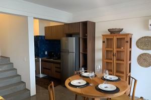 eine Küche mit einem Holztisch und einem Kühlschrank in der Unterkunft Hosts BR - Cobertura duplex frente mar in Fortaleza
