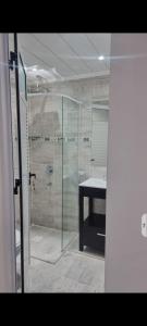 La salle de bains est pourvue d'une douche en verre et d'un lavabo. dans l'établissement AB & JOPIE, à Posadas