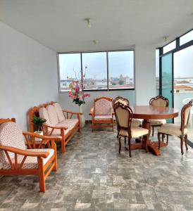 Departamento exclusivo Punta Negra في بونتا نيغرا: غرفة مع طاولة وكراسي ونوافذ