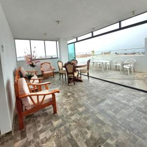 a large room with chairs and tables and windows at Departamento exclusivo Punta Negra in Punta Negra