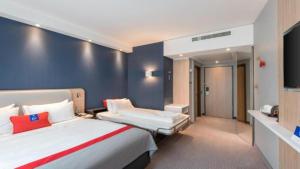 a hotel room with two beds and a television at Holiday Inn Express - Remscheid in Remscheid