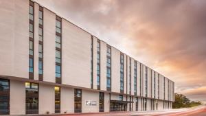 un grand bâtiment blanc avec un coucher de soleil en arrière-plan dans l'établissement Holiday Inn Express - Remscheid, à Remscheid