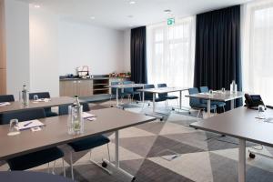 een conferentiezaal met tafels, stoelen en ramen bij Holiday Inn Express - Remscheid in Remscheid