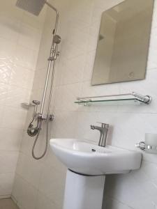 W łazience znajduje się umywalka oraz prysznic z lustrem. w obiekcie Serengeti Rest Lodge w mieście Afienya