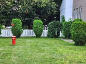 a red fire hydrant in a yard next to a white fence at Timeless Tranquility, a place near everything! in Longueuil
