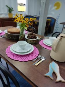 - une table avec des assiettes de nourriture et un gâteau dans l'établissement Maga hospedagem, à Penha